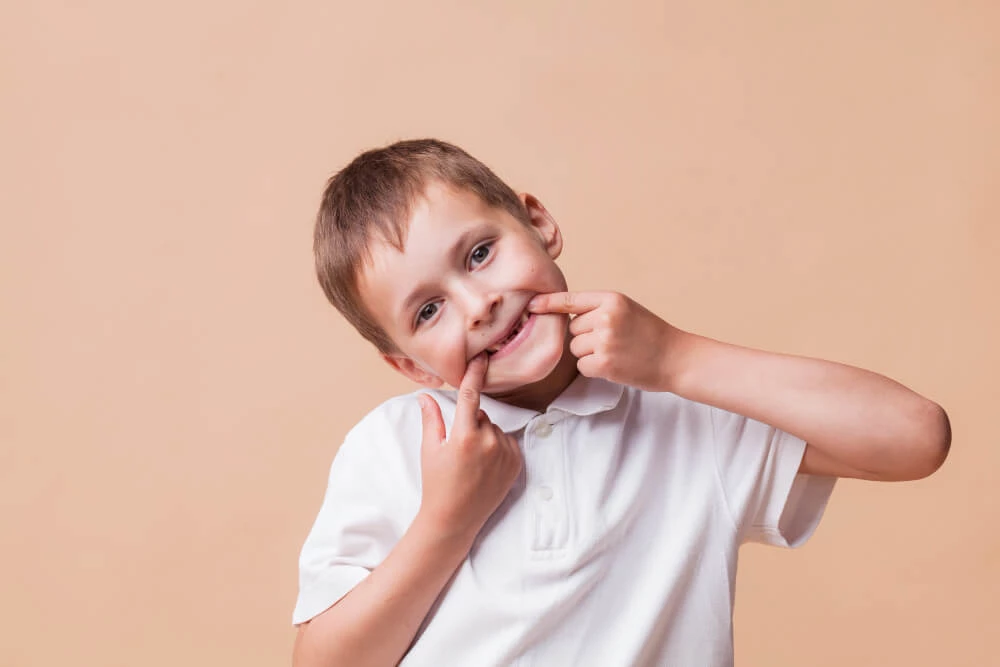 Portrait Little Boy Looking Camera Teasing Beige Background (1)